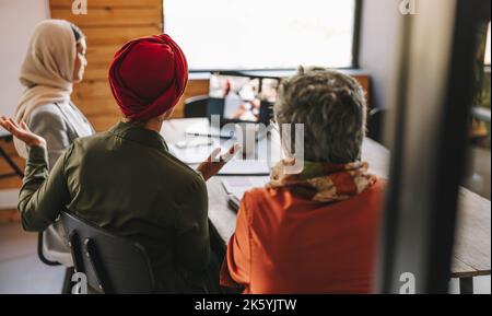 Team of multicultural businesswomen having a discussion with their business partners during an online meeting. Diverse businesswomen attending a video Stock Photo