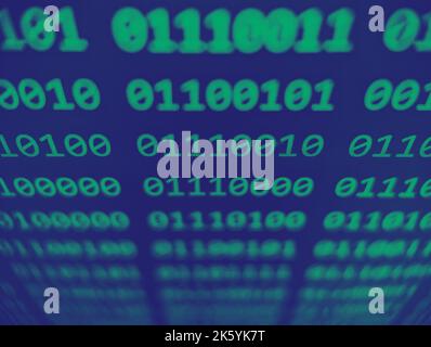 Closeup view of binary computer code with 1s and 0s displayed on a screen with a focus blur effect in green and blue Stock Photo