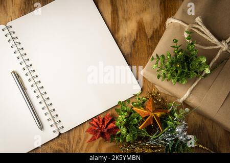 Christmas background with copy space on a blank notebook with a pen on a wooden table Stock Photo