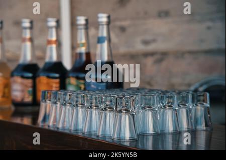 Brandy glasses and bottles of various alcohol drinks on a table Stock Photo