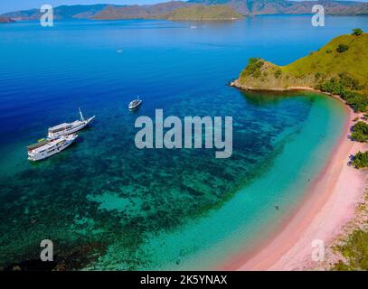 Aerial view of a Pink beach in Flores, with a tourist and a yatch. Stock Photo