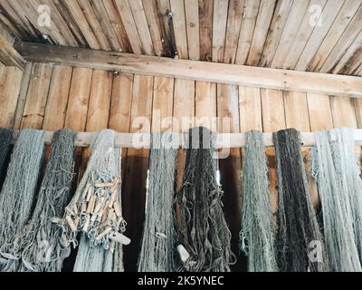 A close up of fishing nets hanging from a wood pole Stock Photo