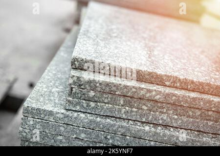 Gray granite polished tiles stacked outdoors before laying on the floor Stock Photo