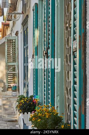 Wooden windows and shutters painted blue in house at sunset Stock Photo