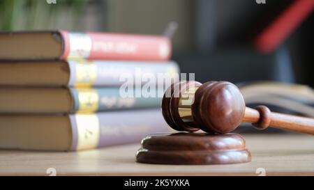 Judge gavel on wooden sounding block and pile of law books Stock Photo