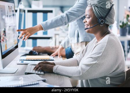 African american call centre telemarketing agent receiving training and assistance from supervisor while working on a computer in an office. Confident Stock Photo