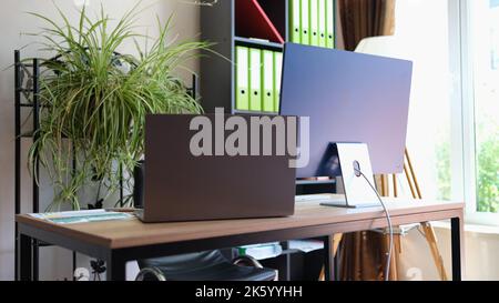 Comfortable office interior with modern laptop and pc Stock Photo
