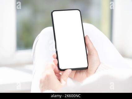 woman user customer hold cellphone mockup with white screen in hand. Use mobile shopping app, check social media news, texting mobile sms order food d Stock Photo