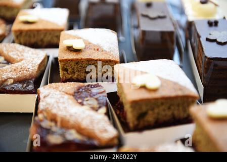 From above closeup pieces of tasty cakes placed in carton boxes on stall in bakery Stock Photo