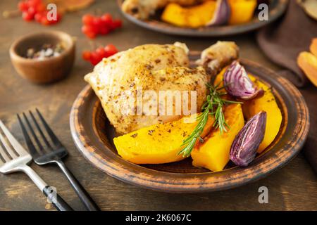 Homemade Thanksgiving dinner ripe pumpkin and Thanksgiving turkey on a dark wooden table. Stock Photo