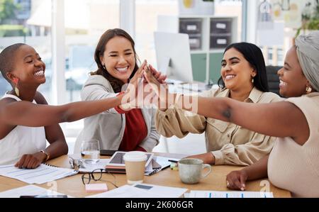 Diverse group of smiling ethnic business women giving high five after brainstorm meeting in office. Ambitious happy confident professional team of Stock Photo
