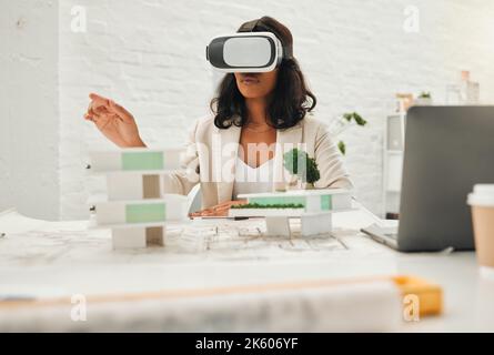 Young designer using AI simulator to plan building. African American architect using VR goggles.Young engineer using a virtual reality headset in her Stock Photo