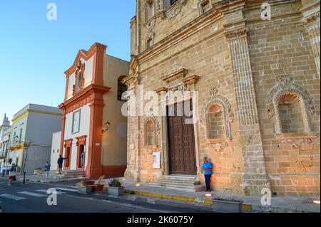 An elderly man standing in front of San Domenico al Rosario church in warm evening sunshine in old town Gallipoli, Apulia (Puglia), Italy. Stock Photo