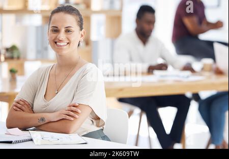 Portrait of a happy mixed race businesswoman sitting with her arms crossed in an office at work. Confident female businessperson smiling while sitting Stock Photo