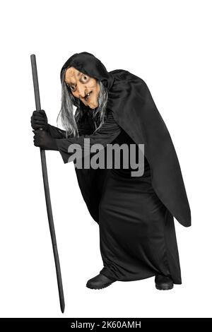 Old witch in a cloak standing with a stick isolated over white ...