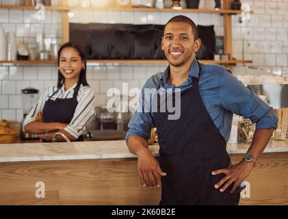 Two business partners together in their coffeeshop. Young couple collaborate in the kitchen of their cafe. Portrait of colleagues together in their Stock Photo