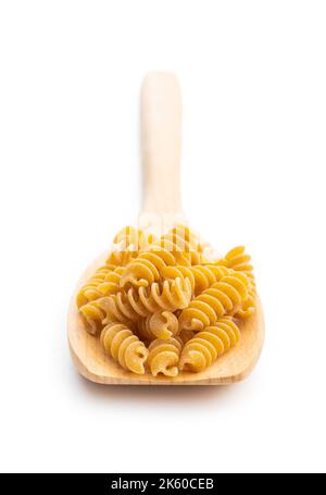 Uncooked whole grain pasta isolated on white background. Raw pasta on the spoon. Stock Photo