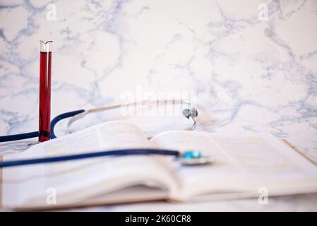 Stethoscope on the pages of a text book and blood analysis Stock Photo