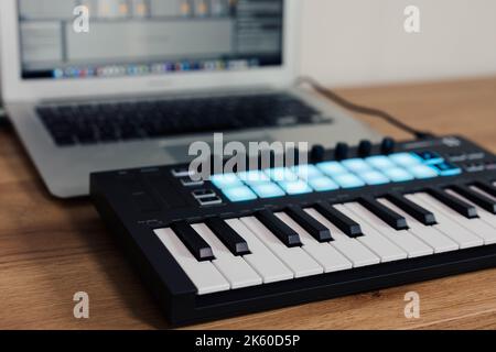 Midi Keyboard musician playing midi keyboard for arranging music on laptop computer Music production technology concept Stock Photo
