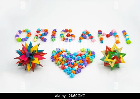 Origami sign and heart creative concept made of bunch of multi colored origami stars Stock Photo