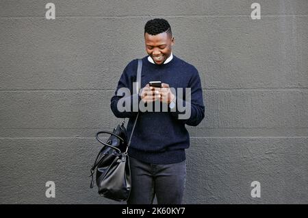 Businessman using his cellphone while walking in the city. Man using cellphone while commuting to work. Using internet while walking outside. Man Stock Photo