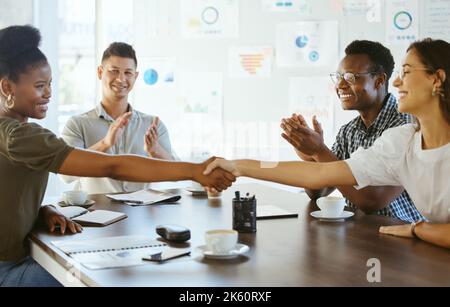 Two businesswoman shaking hands in a meeting at work. Business professionals greeting and making deals with each other. Hispanic boss hiring an Stock Photo