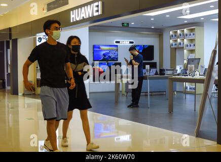 BEIJING, CHINA - AUGUST 28, 2022 - Customers pass in front of a Huawei store at Wangfujing Commercial Street in Beijing, China, on Aug 28, 2022. Stock Photo