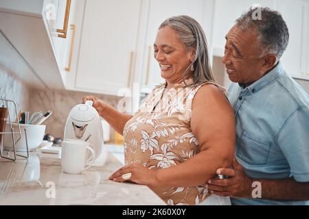 Tea, couple and retirement with a man and woman using a kettle in the kitchen of their home together. Love, morning and romance with a senior male and Stock Photo