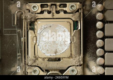 Very dirty computer processor. Dusty CPU microchip on a computer motherboard with traces of cooler grease. The electronic board in the computer Stock Photo