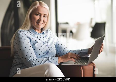 Cheerful lady posing for the camera with her portable computer Stock Photo