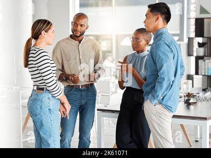 Group of diverse businesspeople having a meeting in a modern office at work. Business professionals talking and sharing ideas. Businesspeople planning Stock Photo