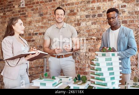 Group of diverse architects discussing plans, blueprints and schematics during a meeting in their office boardroom. Business people brainstorming and Stock Photo