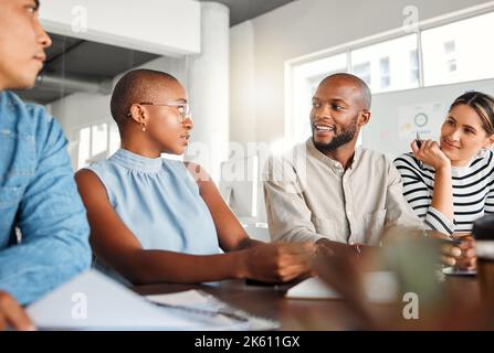 Group of serious focused diverse businesspeople having a meeting in an office at work. Business professionals talking in an office. Businesspeople Stock Photo