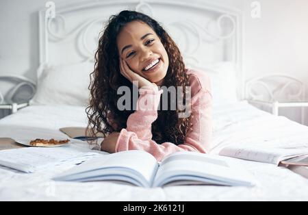 Portrait college student studying in bedroom with research notebooks, exam reading and education project at home. Happy woman, young girl and academic Stock Photo