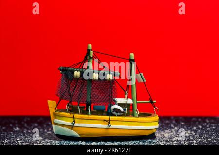 Ship toy on a red background with some specific elements Stock Photo