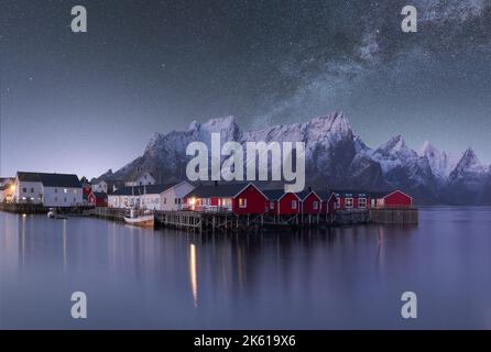 Spectacular scenery of glowing stars of Milky Way in night sky over over residential houses located in highlands near lake in Norway at night Stock Photo