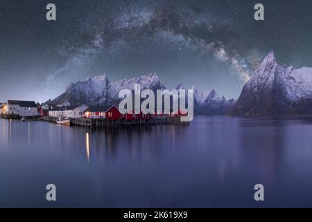 Spectacular scenery of glowing stars of Milky Way in night sky over over residential houses located in highlands near lake in Norway at night Stock Photo