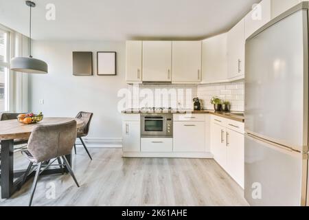 Table with fruits placed in light spacious kitchen zone with modern appliances in modern apartment Stock Photo