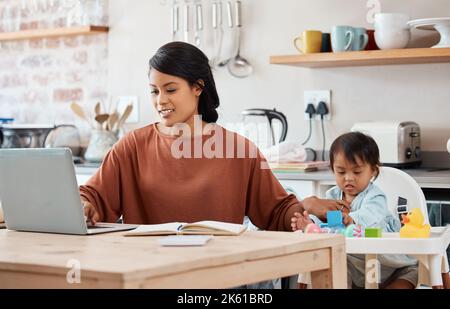 Children, down syndrome and family with a working mother and child in the kitchen of their home. Kids, disability and freelance with a business woman Stock Photo