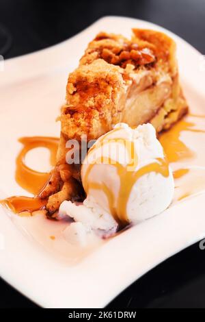 Apple pie served with vanilla ice cream, selective focus Stock Photo