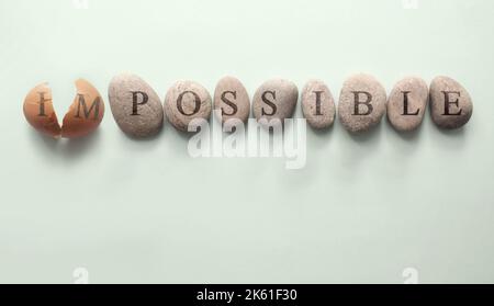 Egg shell cracking open changing word from impossible to possible Stock Photo