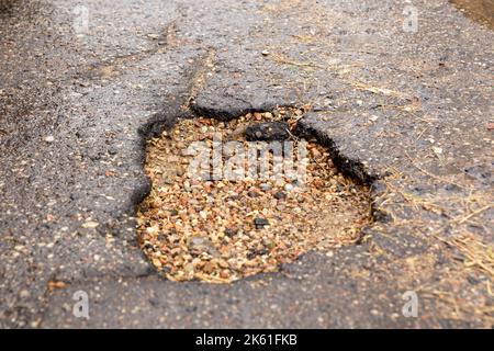 Water filled pot hole in the road. Copy space area for construction road repair designs and concepts Stock Photo