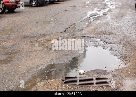 Water filled pot hole in the road. Copy space area for construction road repair designs and concepts Stock Photo