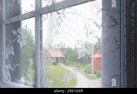 View through lace curtains with houses in background Stock Photo