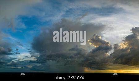Cumulonimbus clouds forming before thunderstorm on evening sky. Changing stormy cloudscape weather at sunset Stock Photo