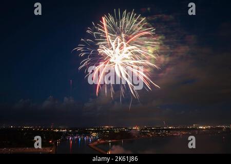 Aerial view of bright fireworks exploding with colorful lights against dark night sky on US Independence day holiday Stock Photo