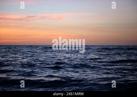 Dramatic red ocean waves at sunset with soft evening sea dark water Stock Photo