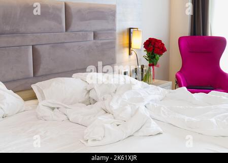 wrinkled bed after a stormy night of love. Closeup on soft white and crumpled blanket in bedroom Stock Photo
