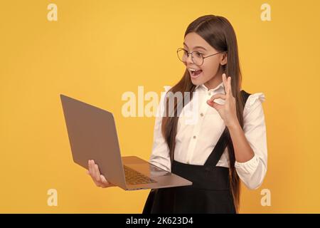 amazed kid in school uniform and glasses wavig hello to laptop screen, communication Stock Photo