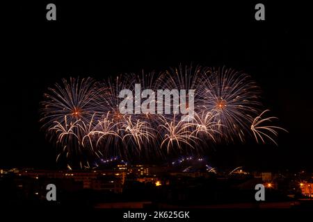 bright lilac and orange fireworks in a night sky Stock Photo
